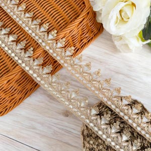 May include: Gold and silver trim with a beaded design. The trim has a scalloped edge and is perfect for adding a touch of elegance to any project.