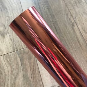 Rose gold chrome adhesive mirror vinyl in sheet form showing its reflective metallic surface