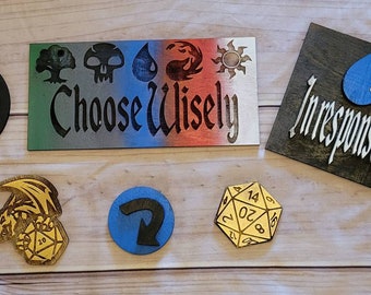 May include: A set of wooden crafts featuring a variety of designs, including a dragon, a die, a symbol, a water drop, and a sign that reads "Choose Wisely".