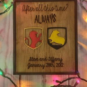 May include: A wooden sign with the text "After all this time? ALWAYS" and two crests, one red and one yellow. The sign also includes the text "Steve and Tiffany January 28th, 2012".