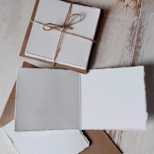 K&ouml;nnte beinhalten: Ein Satz von drei leeren Karten mit braunen Papierumschl&auml;gen. Die Karten sind aus strukturiertem, cremefarbenem Papier. Die Umschl&auml;ge sind aus braunem Papier mit rauer Textur.