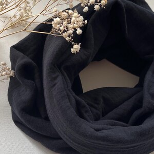 Peut inclure: Une &eacute;charpe infinie noire, douce et extensible en tissu.