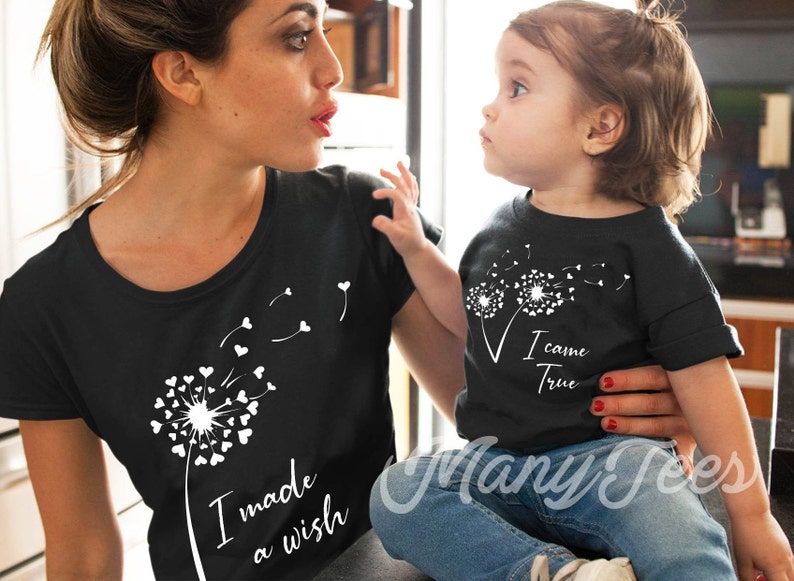 May include: A black t-shirt with a white dandelion design and the text "I made a wish". A second black t-shirt with a white dandelion design and the text "I came true".