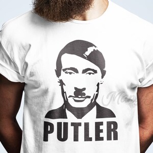 May include: White t-shirt with a black and white image of a man with a mustache and the word "PUTLER" printed below.