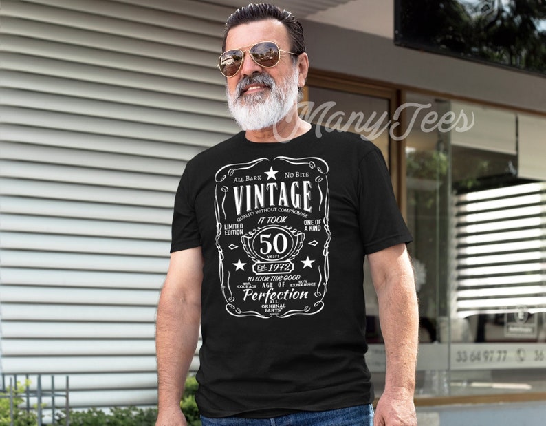 May include: Black t-shirt with a white vintage label design. The label says "Vintage" and "It Took 50 Years" with a star and the year "Est. 1972".