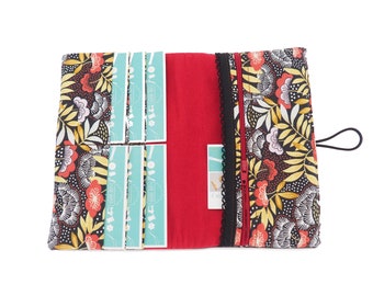 May include: A black and red fabric wallet with a floral pattern and a zipper closure. The wallet has multiple card slots and a small pocket for cash.