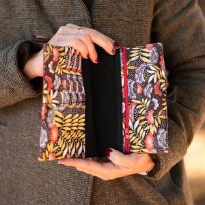 Cartera de mujer Sophie en piel sintética en tonos burdeos, rojo y dorado, y tejido con estampado de hojas.