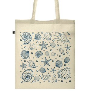 May include: A beige tote bag with a blue and white design of seashells and starfish. The bag has a long handle.
