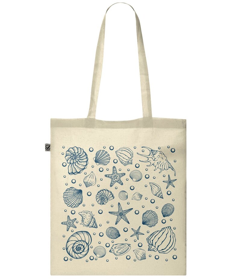 May include: A beige tote bag with a blue and white design of seashells and starfish. The bag has a long handle.