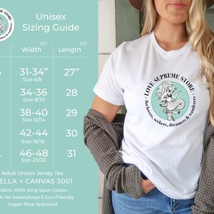Op de afbeelding: Unisex maattabel voor een t-shirt met een zeemeermin-afbeelding en de tekst "LOVE SUPREME STORE for lovers, seekers, dreamers & wanderers". De tabel toont maten XS tot en met XL met de bijbehorende breedte- en lengtematen in inches.