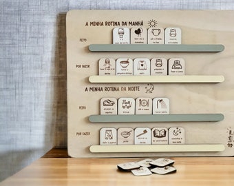 May include: A wooden board with a daily routine chart for children. The chart is divided into two sections: "A Minha Rotina da Manhã" and "A Minha Rotina da Noite". Each section has a list of activities with corresponding images. The board is made of light wood and has a cream and green color scheme.