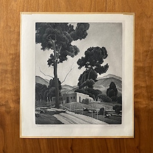 May include: A black and white print of a Southwestern adobe house with a mountain backdrop. The house is surrounded by trees and bushes. The print is titled "Mountain Outcroppings" and signed "Charles "C"  R"  Capper".