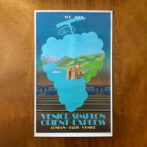 May include: Vintage travel poster for the Venice Simplon-Orient-Express train. The poster features a stylized illustration of a lake, mountains, and a building, all within a cloud-shaped design. The text "Venice Simplon Orient-Express" is at the bottom.