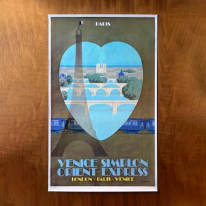 May include: Vintage travel poster featuring the Eiffel Tower and a heart-shaped design with a Parisian cityscape. The poster has blue and brown tones, with the text "Paris" at the top and "Venice Simplon Orient-Express" at the bottom.