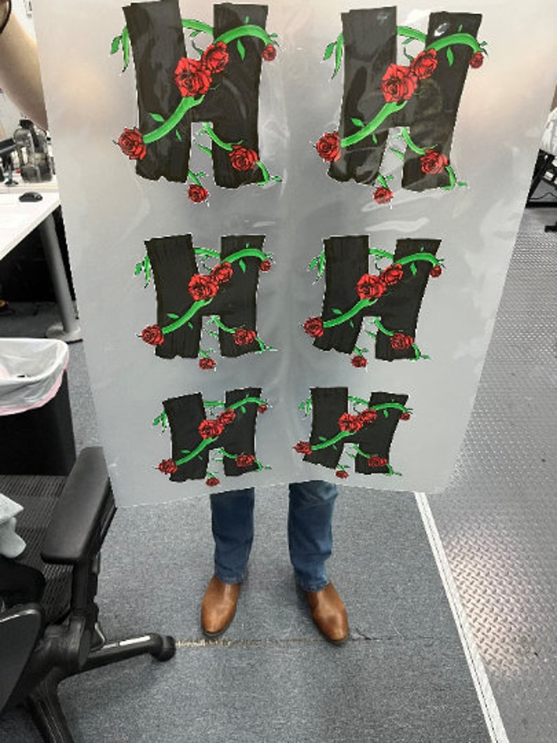 May include: Six black vinyl stickers with a stylized letter H surrounded by green vines and red roses.