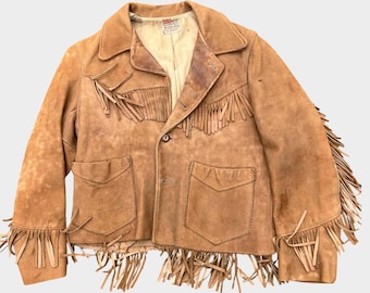 Puede incluir: Una chaqueta de ante color tostado con flecos largos en el pecho, las mangas y el dobladillo. La chaqueta incluye un cuello puntiagudo, dos bolsillos delanteros con solapas en forma de V y cierre de botones con etiqueta Levi's.