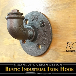 May include: A rustic industrial iron hook made of dark brown metal. The hook is mounted on a circular plate with screw holes and the text "1974". The design is steampunk urban design.