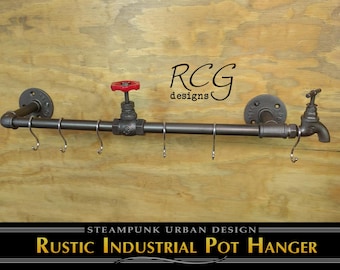 Pode incluir: Um cabideiro industrial rústico feito de tubos de metal escuro, com uma torneira e uma válvula vermelha. O design inclui vários ganchos para pendurar objetos, com o texto "RCG designs" e "Steampunk Urban Design".