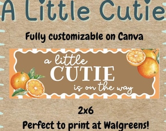 以下が含まれることがあります： 「A Little Cutie is on the way」のテキストが入ったバナーデザイン。バナーにはオレンジと葉が描かれており、サイズは2x6です。デザインはCanvaで完全にカスタマイズ可能です。