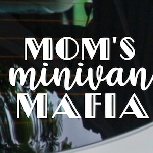 May include: White vinyl decal with the text "MOM'S minivan MAFIA" in a mix of bold and script fonts. The decal is designed to be applied to a vehicle's window or body.