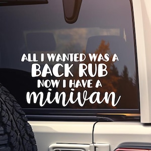 May include: White vinyl decal on the back window of a silver car. The decal reads "All I wanted was a back rub now I have a minivan".