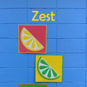 May include: Three colourful fabric squares with a slice of lemon, lime, and orange on a blue brick wall. The text "Zest" is above the squares. A black and white circle with the text "Slice of Pi Quilts" is in the bottom right corner.
