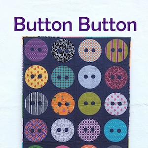 Può includere: Una trapunta con sfondo blu scuro e 18 toppe colorate a forma di bottone. Ogni toppa ha un motivo diverso, tra cui pois, strisce e forbici. La trapunta è intitolata "Button Button" ed è realizzata da "Slice of Pi Quilts".