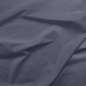 May include: A close-up of a smooth, dark gray fabric with a soft, wrinkled texture.