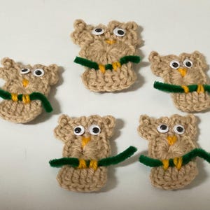 May include: Five crocheted brown owls with googly eyes and green pipe cleaner branches.