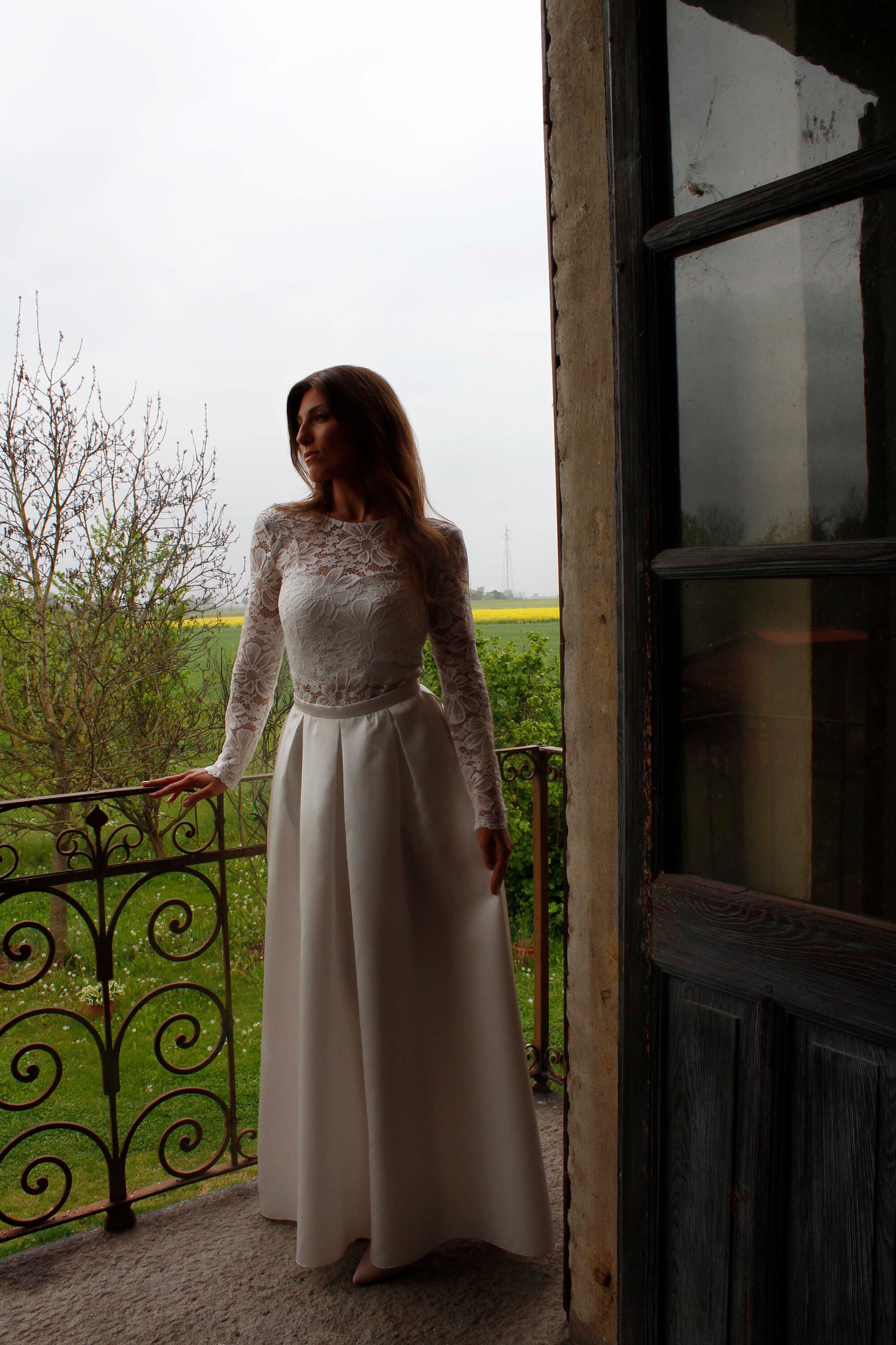 Separates wedding dress composed by a lace bodysuit with open back a satin crop top under it and a long satin skirt with pockets