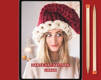 May include: A digital tablet displaying a knitting pattern for a large Santa hat. The pattern is titled "Santa Hat Pattern Large" and is by "Lauren Aston Designs". The image shows a woman wearing the hat, which is red and white.