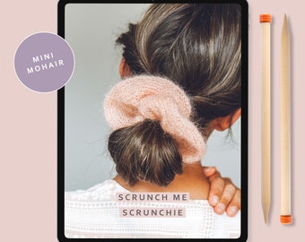 May include: A digital tablet screen displaying a knitting pattern for a "Scrunch Me Scrunchie" made with mini mohair yarn. The pattern is by Lauren Aston Designs. The tablet is on a pink background with two wooden knitting needles.