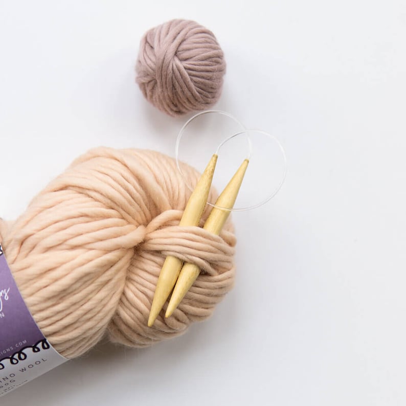 May include: A ball of pale pink yarn with two wooden knitting needles and a clear plastic stitch marker.