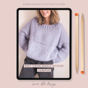 May include: A digital tablet displaying a knitting pattern for a purple sweater with the text "Not Your Basic Stitch Jumper" and "Lauren Afton Designs".