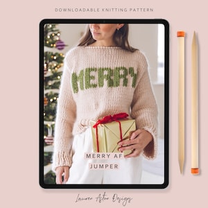 Könnte beinhalten: Eine herunterladbare Strickanleitung, die auf einem Tablet angezeigt wird. Das Bild zeigt einen hellrosa Pullover mit dem Wort "MERRY" in Grün. Ein verpacktes Geschenk mit roter Schleife wird vor dem Pullover gehalten. Der Text "MERRY AF JUMPER" steht darunter.