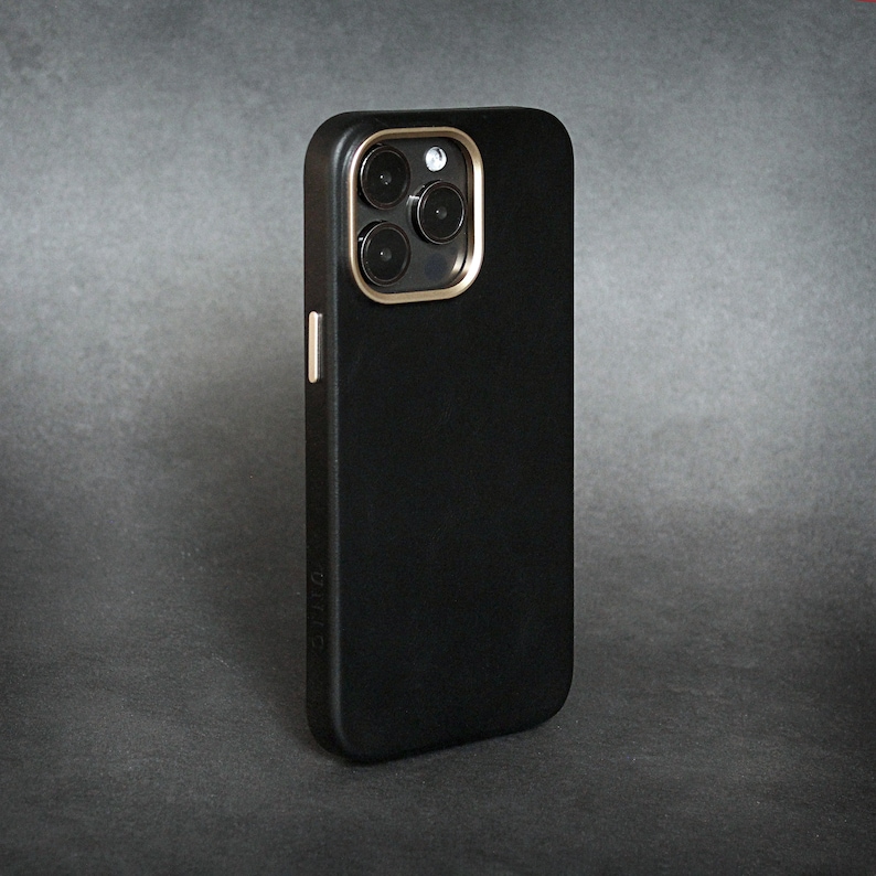 May include: A black phone case with a gold camera ring and four black camera lenses.