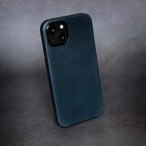 Pu&ograve; includere: Una custodia per telefono di colore blu scuro con una finitura testurizzata. La custodia ha un ritaglio per l'obiettivo della fotocamera sul retro.