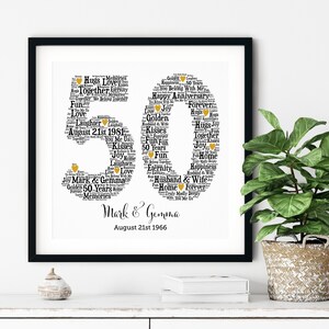 May include: A framed black and white print celebrating a 50th anniversary. The number "50" is formed from words like "Love," "Joy," and "Forever." The names "Mark & Gemma" and the date "August 21st 1966" are at the bottom.