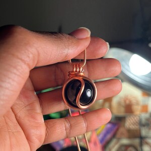 May include: A copper wire wrapped pendant necklace featuring a black yin yang stone.
