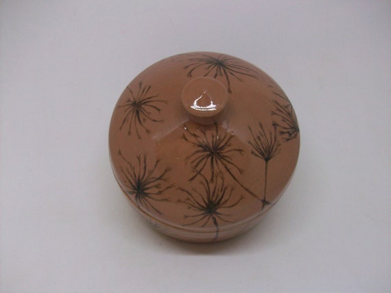 A shiny brown lidded ceramic jar with a hand-painted dandelion seed head — the lid + specific botanical illustration elevates this above typical trinket dishes.