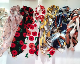 Puede incluir: Colección de coleteros con pañuelos estampados. Los diseños incluyen estampados florales, geométricos y de animales. Los colores van desde pasteles suaves hasta rojos y negros intensos. Los coleteros son de tela.
