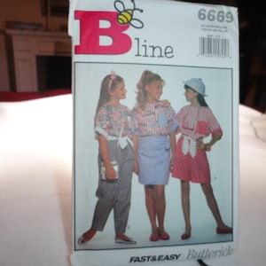 Pode incluir: Um pacote de padrões de costura Butterick com três meninas a modelar diferentes roupas. O pacote tem o logotipo B line com uma abelha e o número 6669. As palavras "Fast & Easy" são impressas na parte inferior.