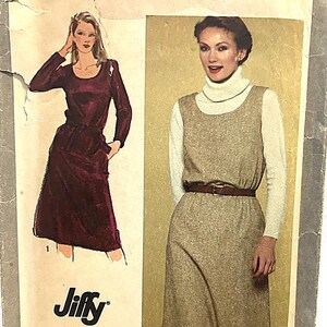 May include: Vintage Simplicity 7001 sewing pattern. The pattern features illustrations of two different dress designs. One dress is a long-sleeved burgundy dress with a belt. The other is a sleeveless dress with a white turtleneck underneath. The word "Jiffy" is visible.