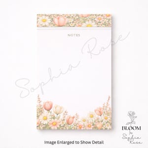 May include: A floral notepad with a white background. The top and bottom edges feature a watercolor design of daisies, tulips, and other flowers in shades of pink, peach, and cream. The word "NOTES" is printed at the top. The text "Image Enlarged to Show Detail" is at the bottom.