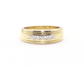 May include: A gold band ring with five small diamonds set in a row.