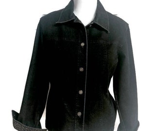 May include: A black denim jacket with a classic collar and button-up front. The jacket features long sleeves with leopard print cuffs. The jacket is displayed on a white mannequin.