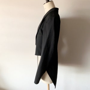 May include: A black tailcoat with a long, flowing tail. The jacket is made of a smooth, luxurious fabric and has a classic, elegant design.