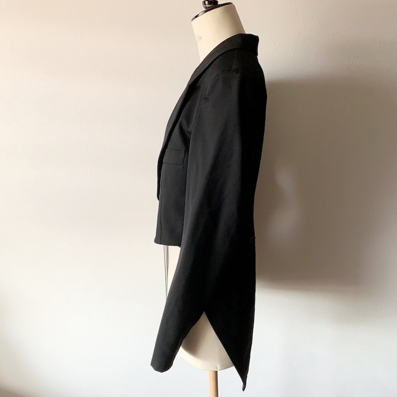 May include: A black tailcoat with a long, flowing tail. The jacket is made of a smooth, luxurious fabric and has a classic, elegant design.