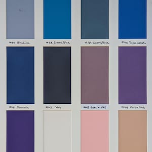 May include: A color swatch chart featuring twelve rectangular samples in a grid. Colors include Blue Lilac, Electric Blue, Country Blue, Blue Wave, Pharaoh, Navy, Grey Violet, Purple Iris, Dark Purple, Barely Pink, Cotton Candy, and Bandage.
