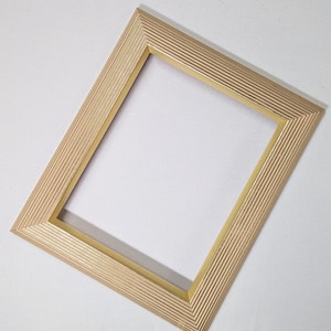 May include: A gold picture frame with a ribbed design. The frame is made of wood and has a rectangular shape.